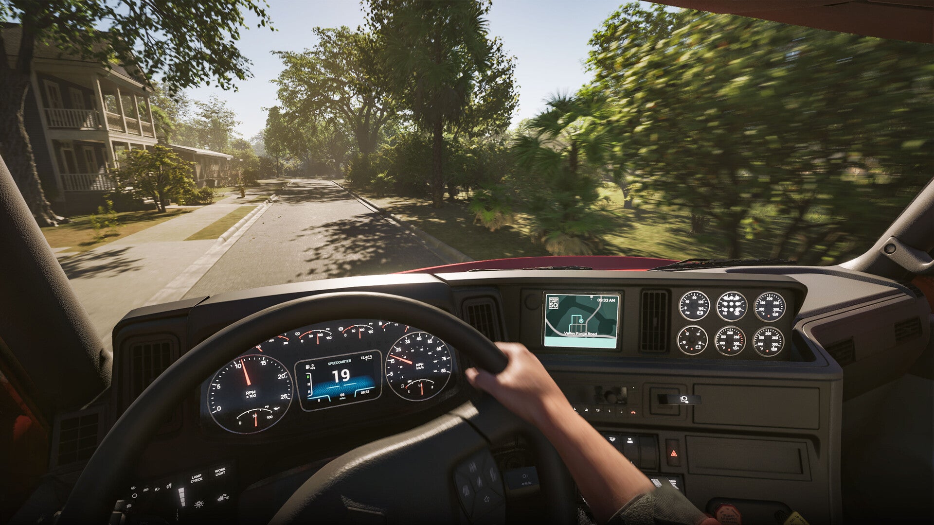 A truck driver's view of a sunny, tree-lined road in Road Kings.