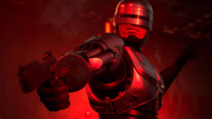 RoboCop points his gun at something out of frame while bathed in sinister red light.