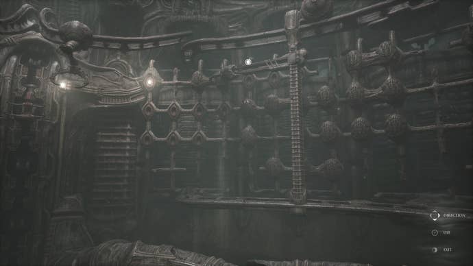 Scorn review - a dimly lit room with spherical skull-like objects on the walls