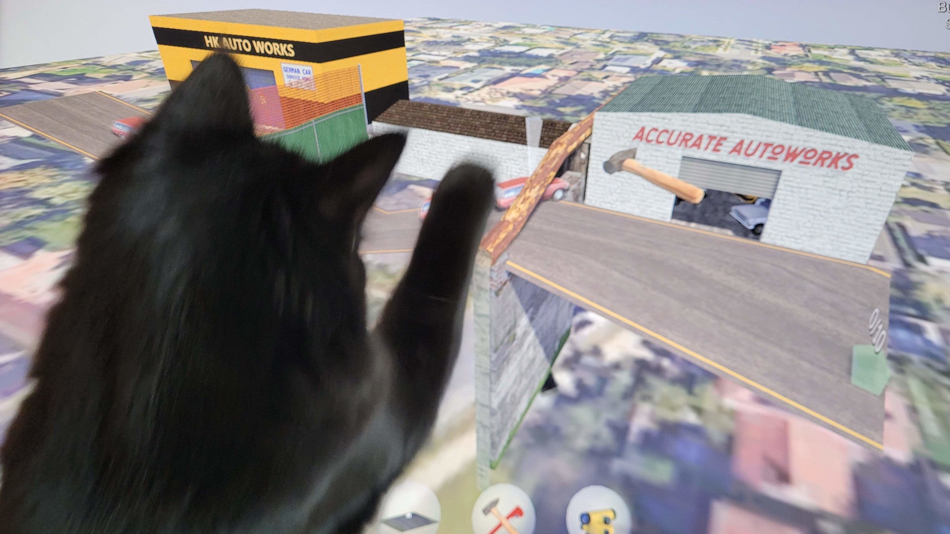 A photo of a black cat watching the game Sebil Engineering on a computer monitor.