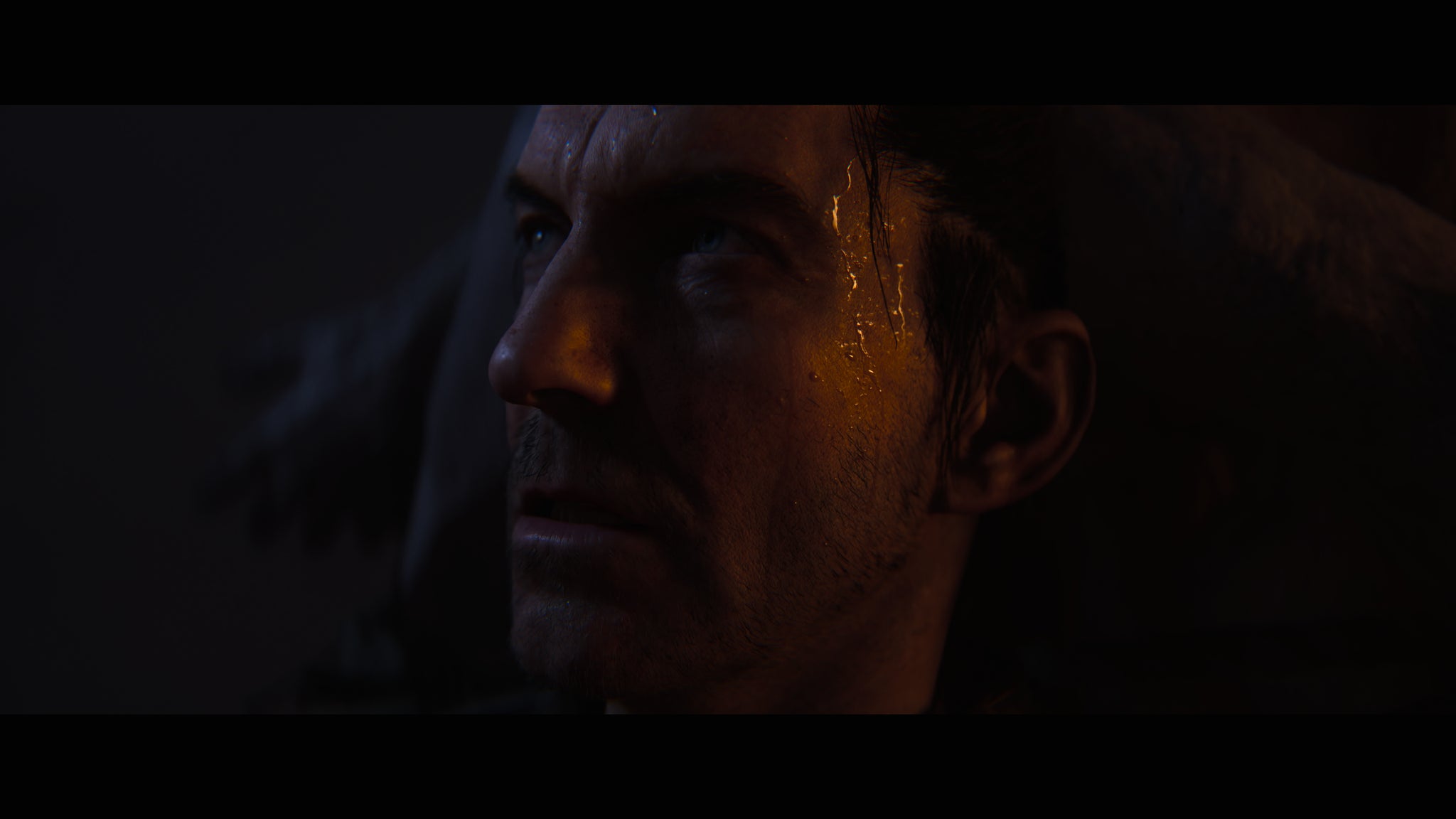 A character in Hellblade 2 sweats visibly as he looks out of frame at something assumedly terrifying. - 6