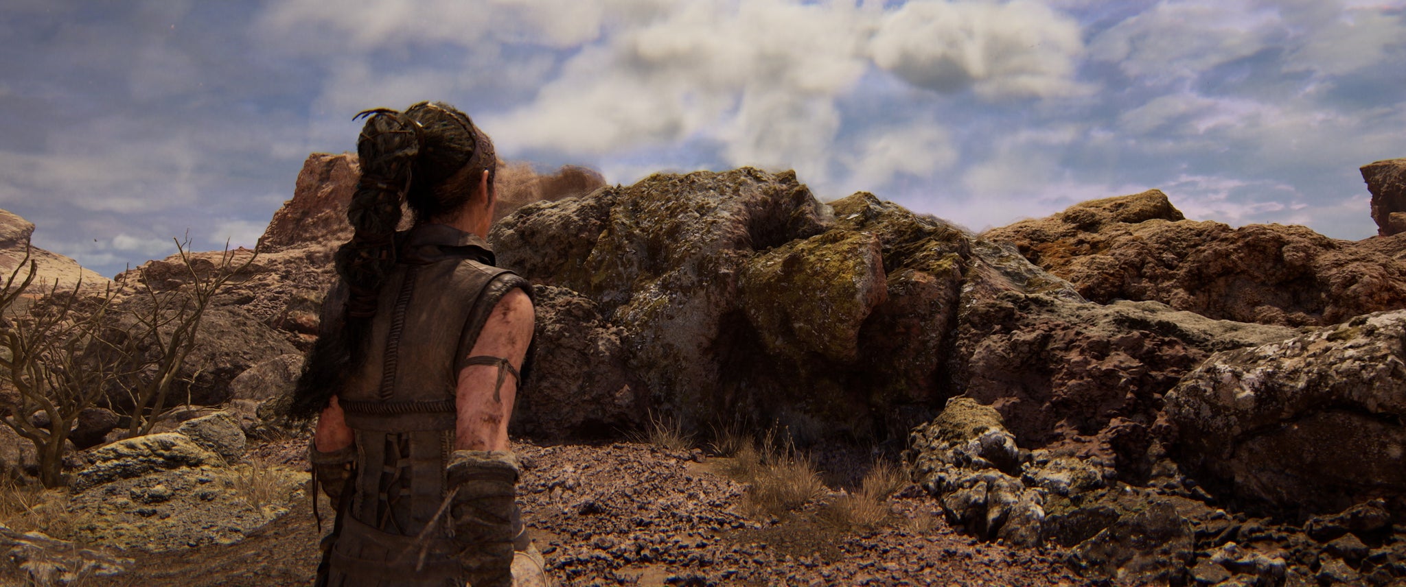 Senua looks at some detailed rocks in Senua's Saga: Hellblade 2. - 4