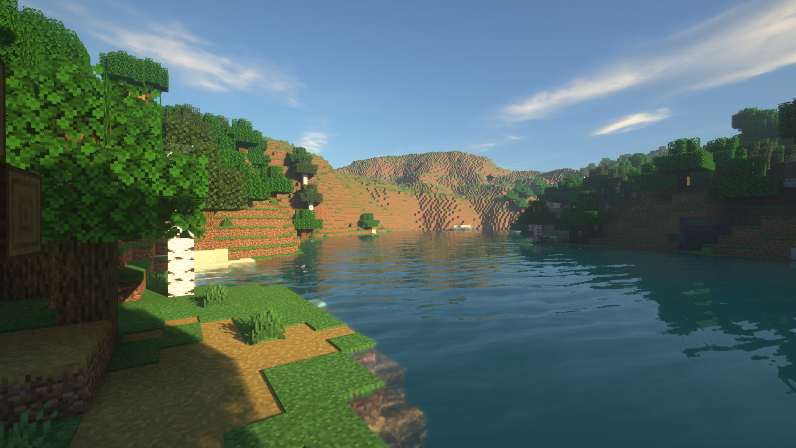 A screenshot of a river in Minecraft, with some trees on either side of the bank and a hill in the distance, taken using SEUS shaders.