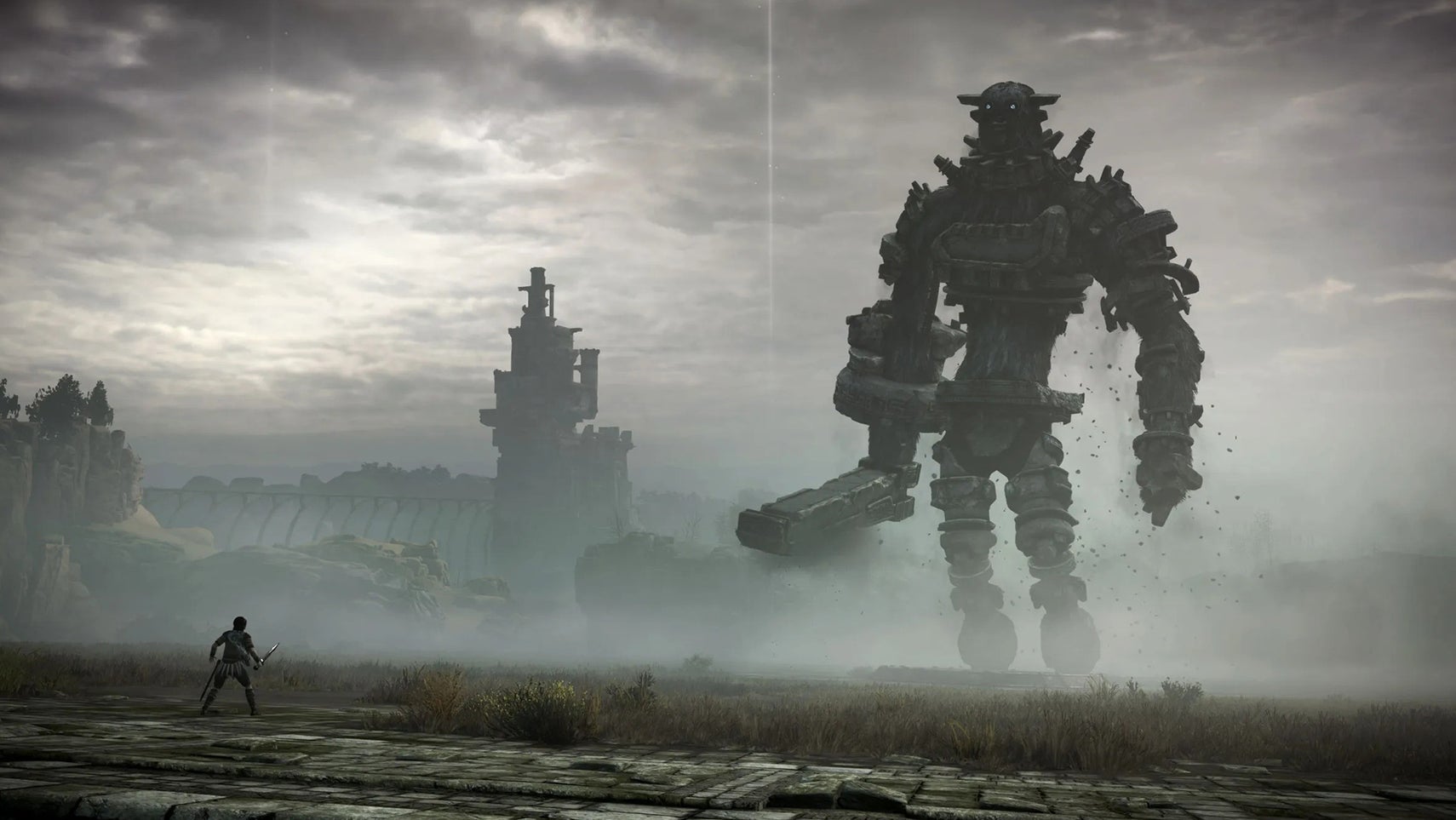 Wander, a man holding a sword, faces a giant creature covered in stones in Shadow of the Colossus. - 1