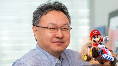 Close up of Shuhei Yoshida with Mario driving a kart in the corner