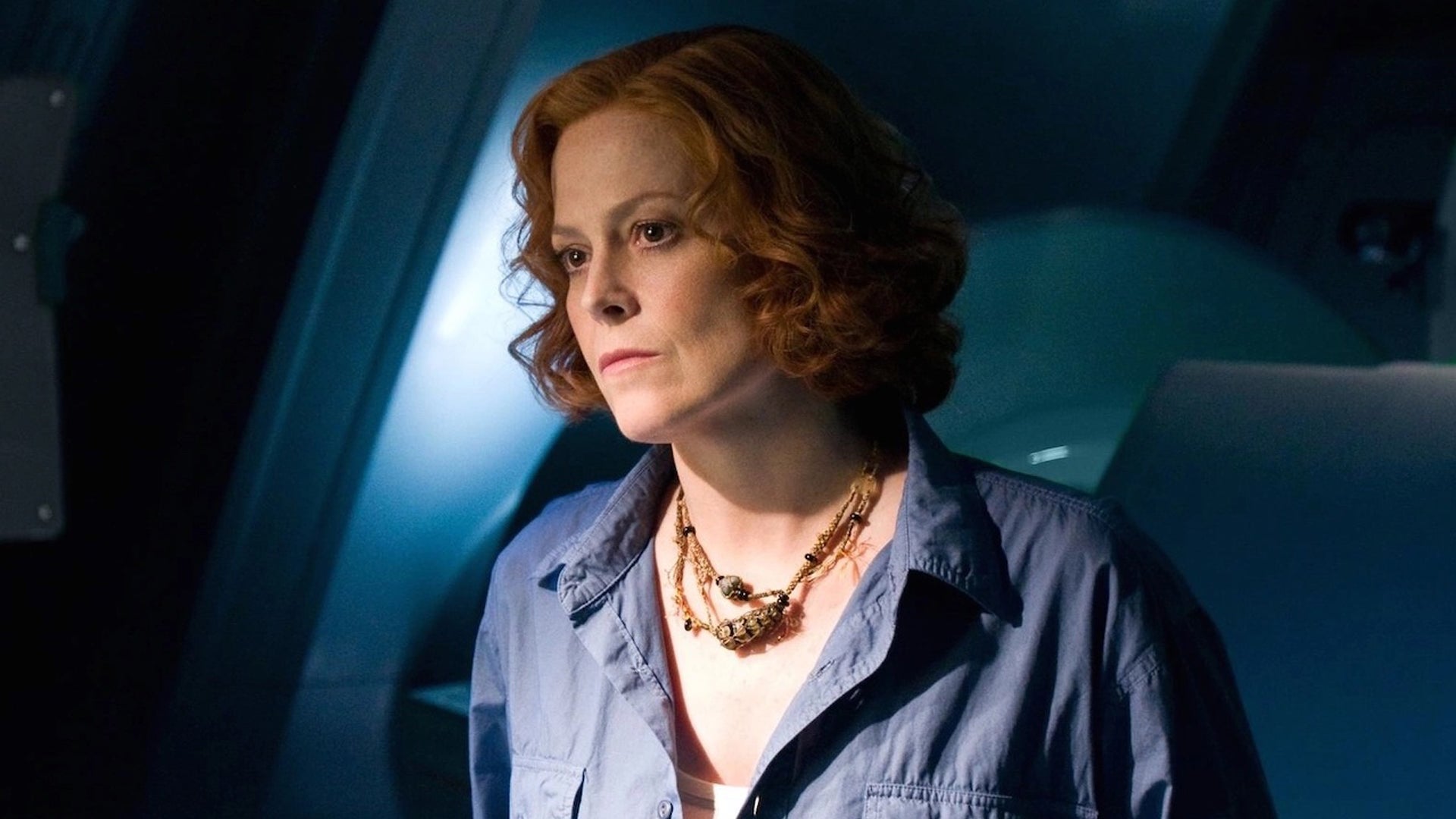 Sigourney Weaver in Avatar, she's stood with a plain expression on her face.