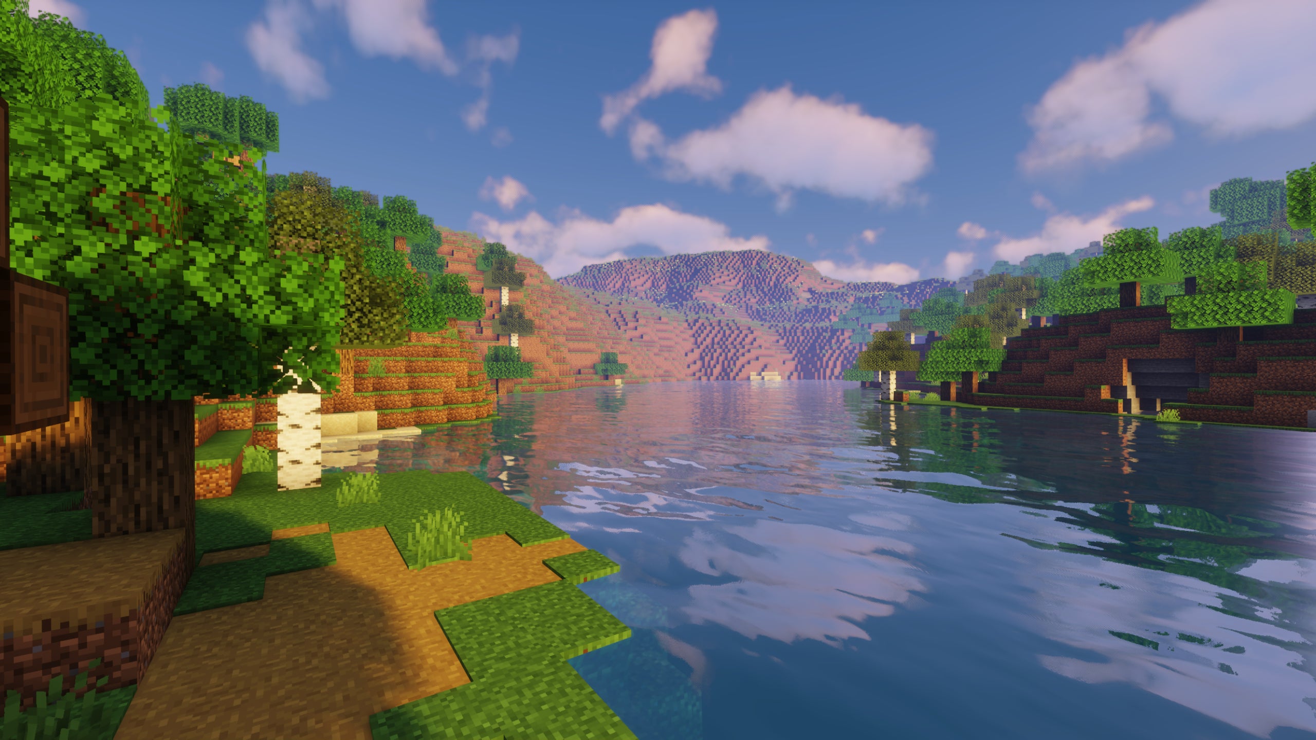 A screenshot of a river in Minecraft, with some trees on either side of the bank and a hill in the distance, taken using Sildur