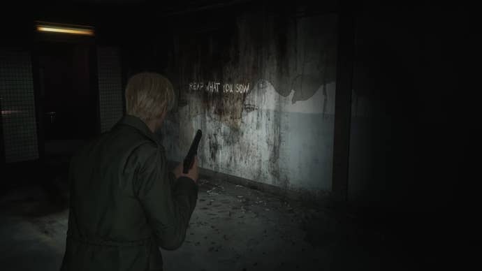 Silent Hill 2 remake screenshot of James holding a pistol, looking at a dirty wall with text on it that reads “reap what you sow."