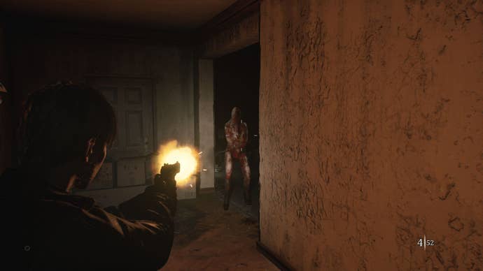 James fires his pistol at a monster in a hallway.