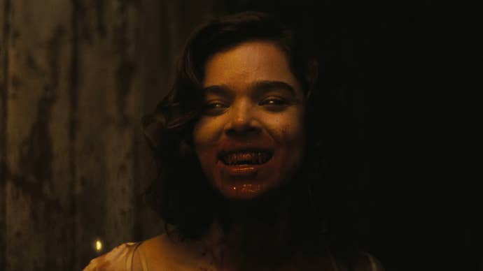 Hailee Steinfeld in Sinners, her mouth is covered in blood, she has sharp fangs and faintly glowing yellow eyes.