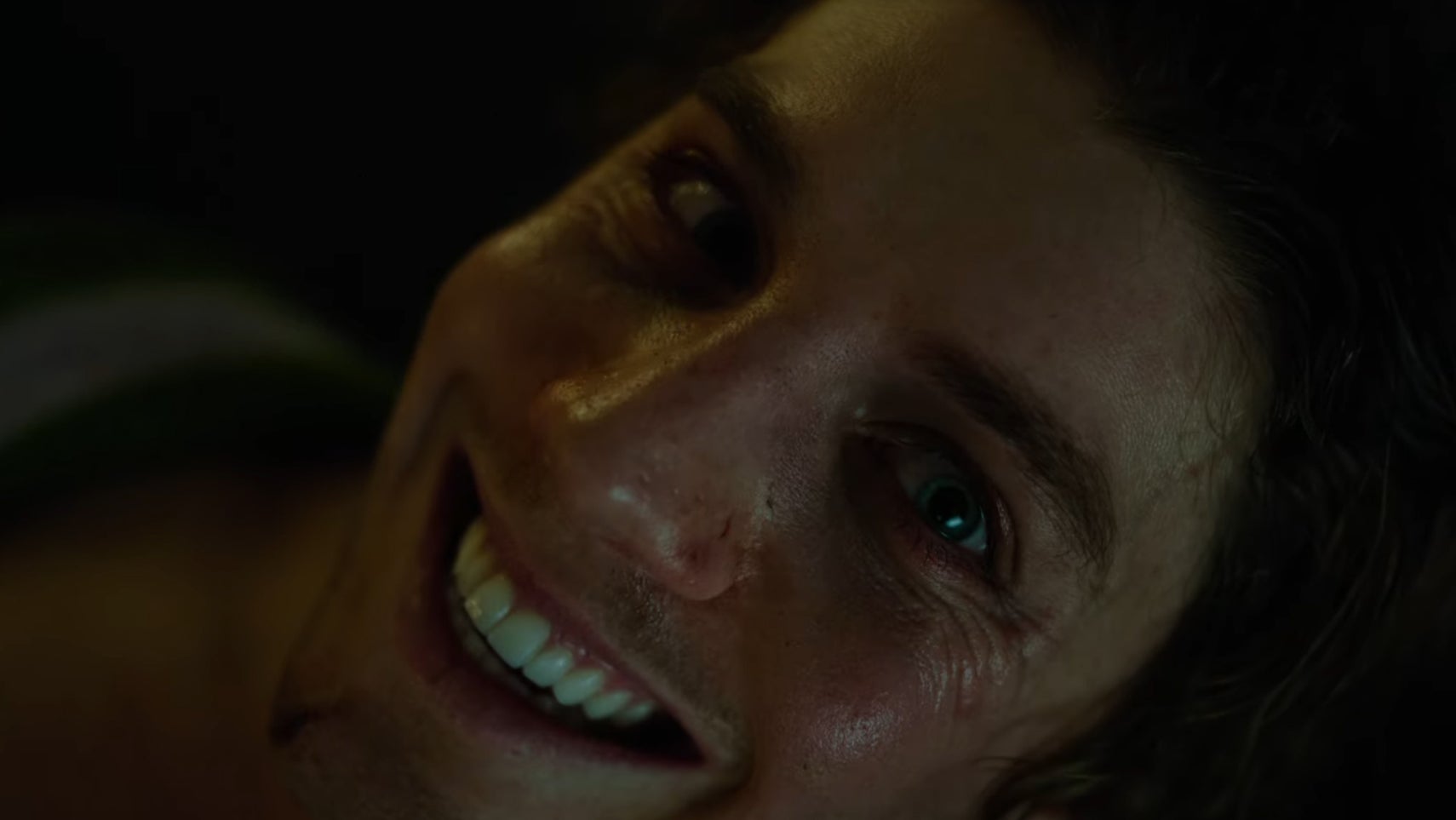 A close-up of a man smiling menacingly in Smile 2. - 1