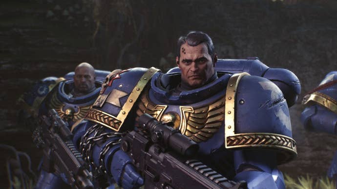 Titus the space marine looks toward the camera in his bulky blue armour.