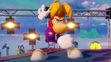 Rayman crouches ready to spring into action on what appears to be a film set with spotlights and rigging behind him.
