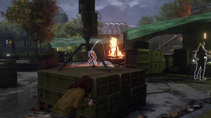 While crouched behind some crates, Mary Jane aims a rock past a bonfire to distract a group of Hunters.