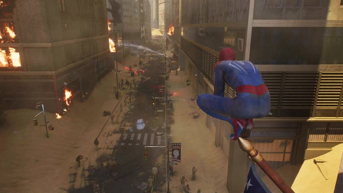 Spider-Man perches on a flagpole, stealthily observing a sand-covered street in New York City as fire crews attempt to control a blaze in the distance.
