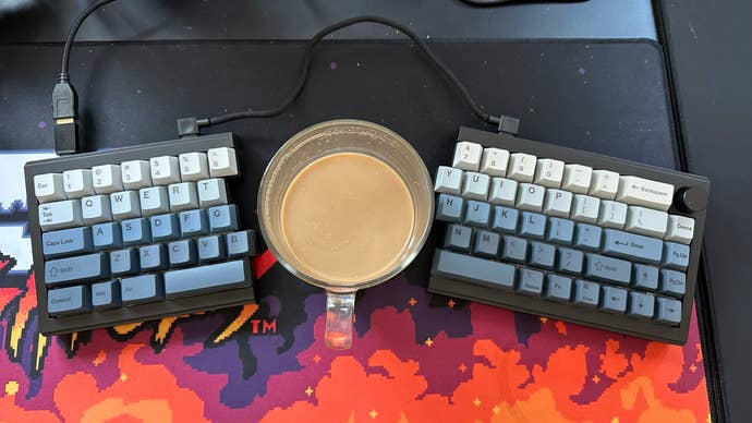 Epomaker Split 65 keyboard with a cup of coffee in the middle of the two halves of the split keyboard