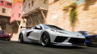 Silver sports car driving down sunlit medieval streets in Forza Horizon 5