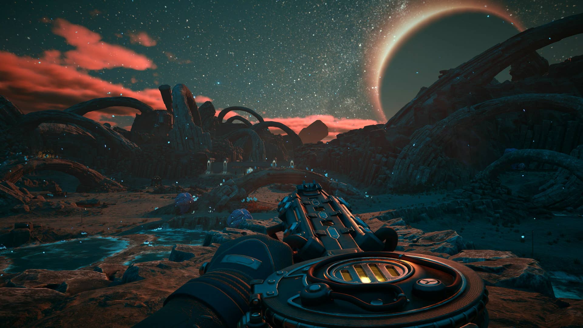A first-person view of a character carrying a large, circular-drummed sci-fi gun on a sci-fi planet. Obligatory low-hanging moon can be seen on the horizon.