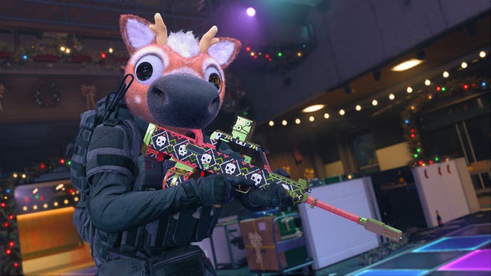 A suited up operator in Modern Warfare 3 holding a rifle with a festive skin and wearing a reindeer mask