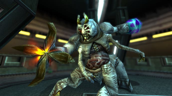 A screenshot from Turok 3: Shadow of Oblivion Remastered showing a bulbous alien enemy with four legs and four arms, including an organic gun arm, standing in a stark, futuristic compound.