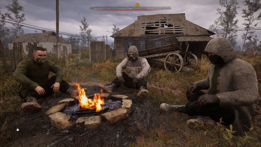 A trio of stalkers sit around a camp fire in the Zone.