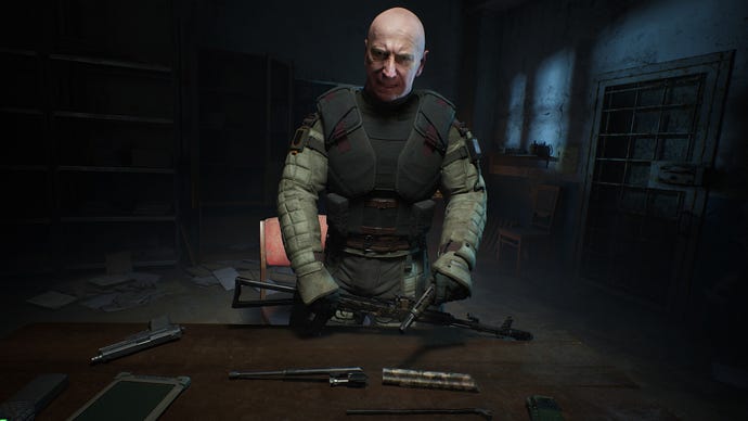 A close-up of Colonel Korshunov, a key character in Stalker 2, bending over a table in a darkened room and looking at the player camera.