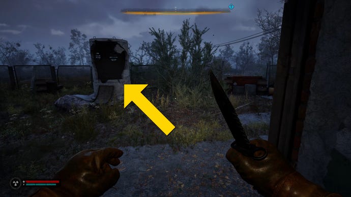 The player in Stalker 2 walks towards a broken stone cylindrical structure outside a building.