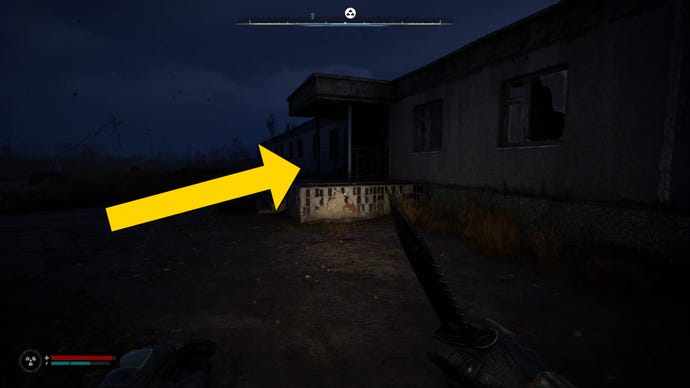 The player in Stalker 2 walks towards the entrance to a barracks at night.