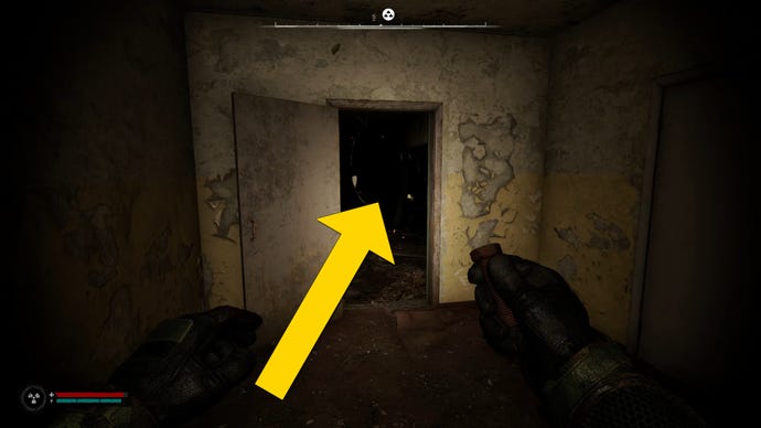 The player in Stalker 2 walks towards an open door where an anomaly can be seen just behind.