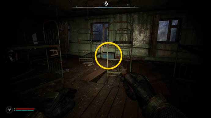 The player in Stalker 2 approaches a blue chest beside two bunkbeds.