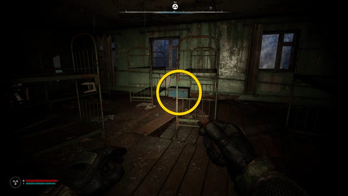 The player in Stalker 2 approaches a blue chest beside two bunkbeds.