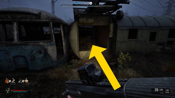 The player in Stalker 2 walks towards a series of ruined containers, one of which has a square hole through which the player can jump.
