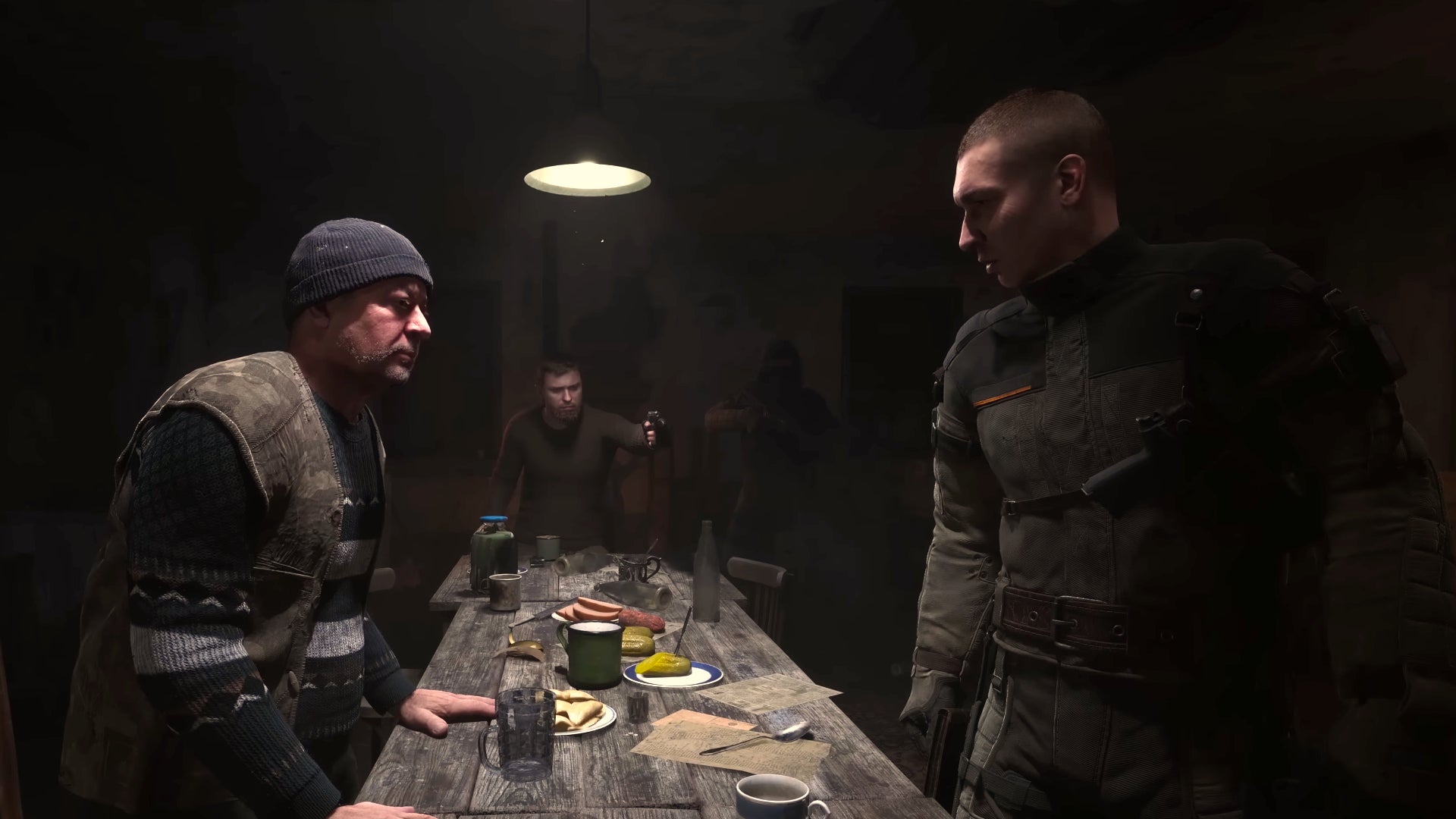 A group of NPCs argue around a table in a dimly lit room in Stalker 2: Heart Of Chornobyl. - 1