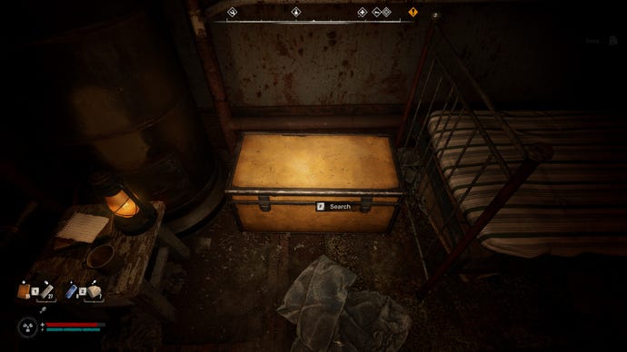 The player in Stalker 2 looks down at their personal stash, an orange chest at the foot of a bed indoors.