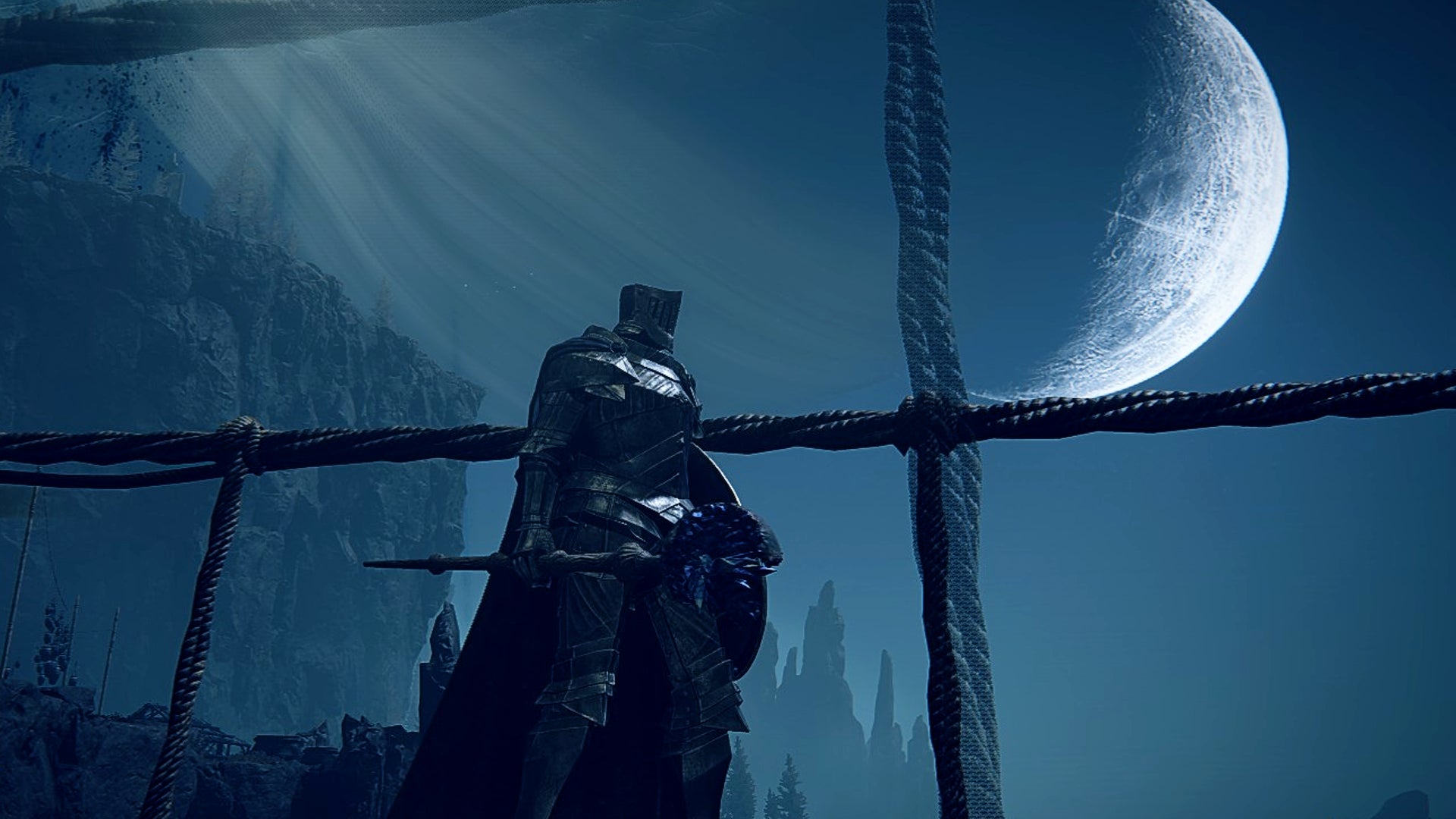 A Tarnished stands on a bridge with the moon overlooking them in Elden Ring: Shadow of the Erdtree. - 1