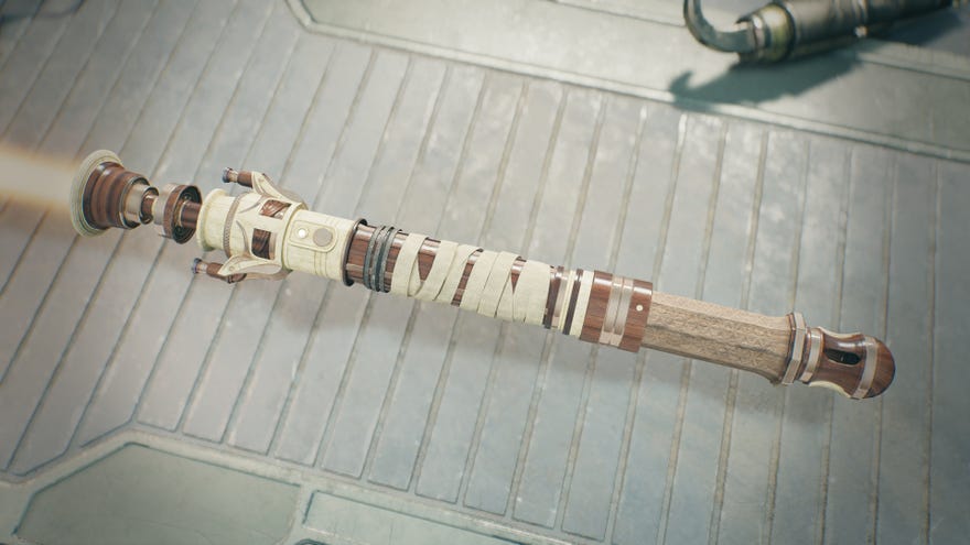 A close-up of a player’s custom-made lightsaber in the Workbench of Jedi: Survivor. The lightsaber is made primarily from wood and bone, and sports and orange blade.