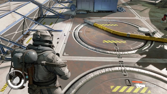 The player in Starfield stands outside in New Atlantis with low health. A mod makes the healthbar red because it is low.