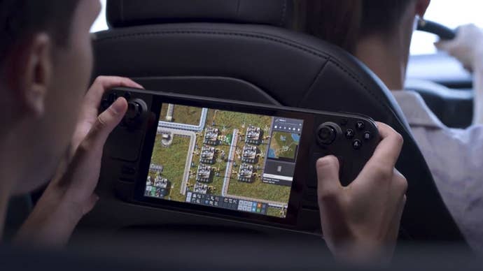A young man plays Factorio on a Steam Deck in the back of a car.