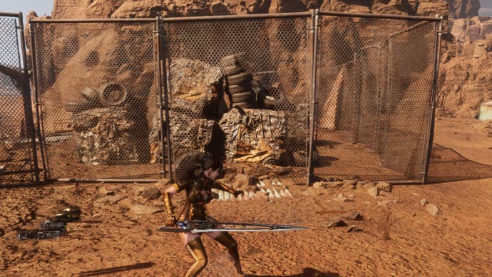 stellar blade eve next to opening in metal fence in wasteland junkyard