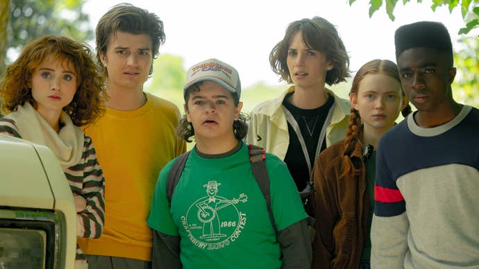 Some of the cast of Stranger Things, including (from left to right) Nancy, Steve, Dustin, Robin, Max, and Lucas, all looking confused at something offscreen.