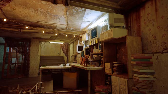 A ginger cat stands on top of a busy desk in Stray
