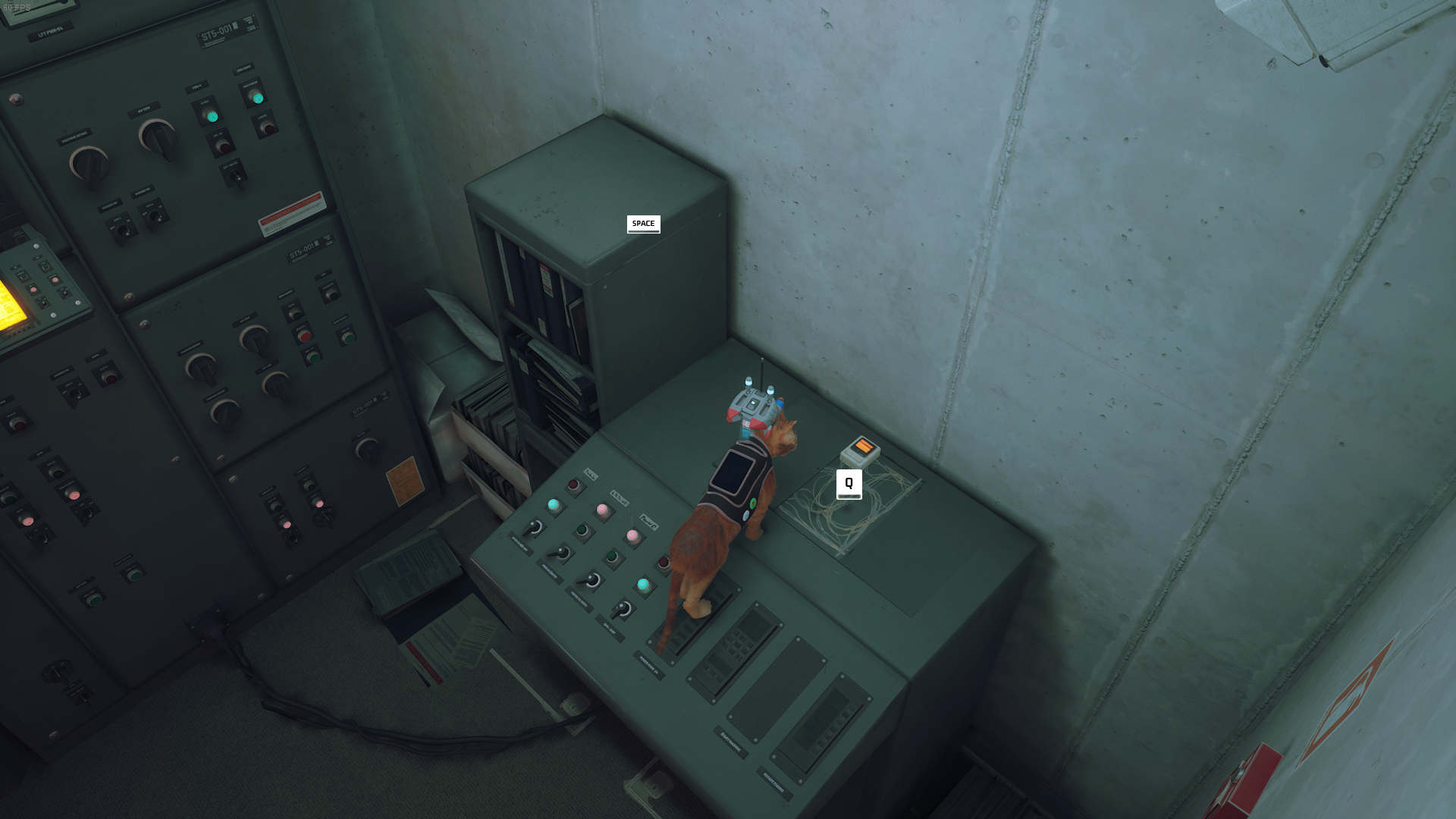 The cat of Stray stands on top of a computer.