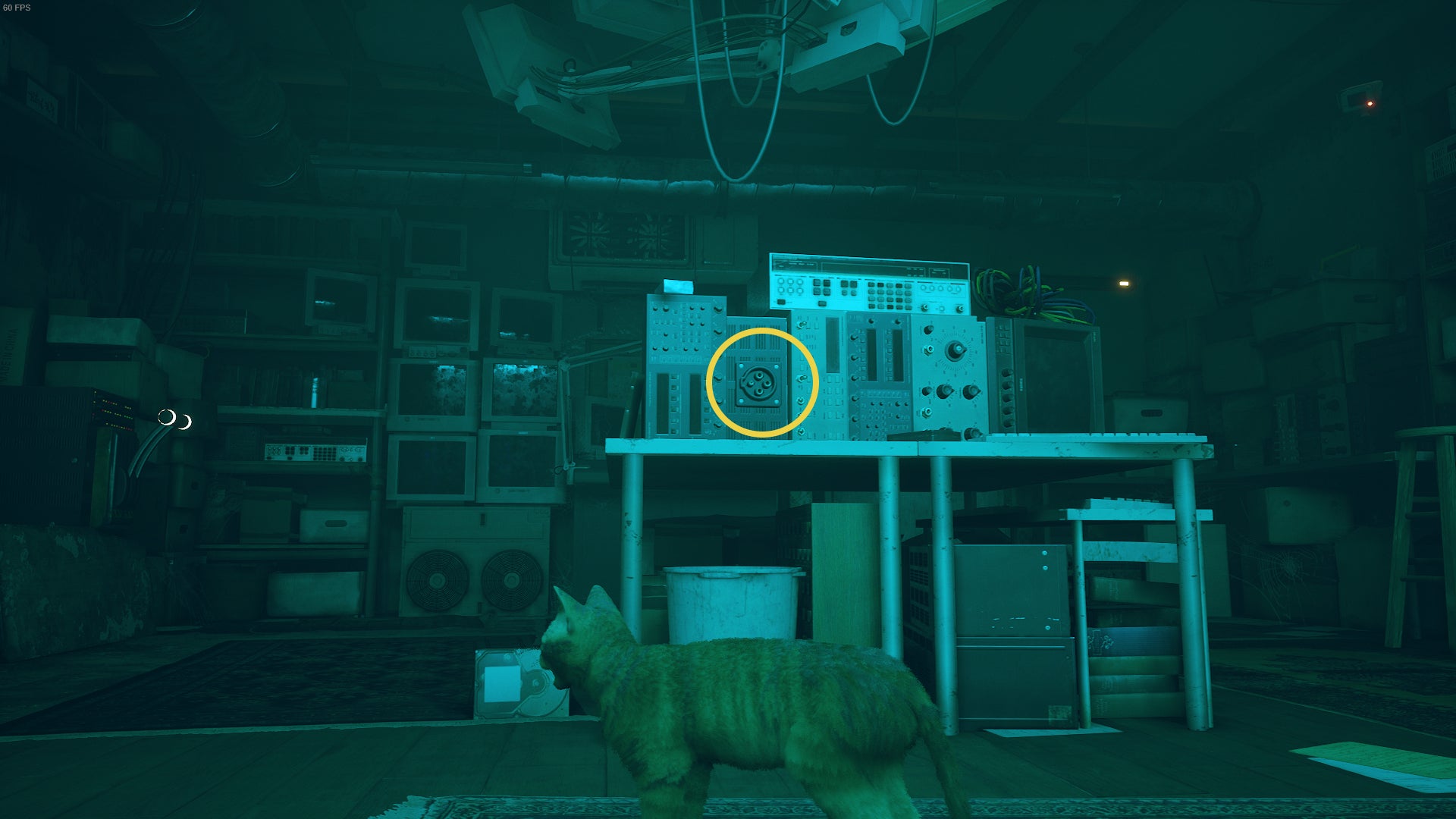 The Outsider, a cat, looks at a desk with a plug on it in The Flats, Stray. - 4