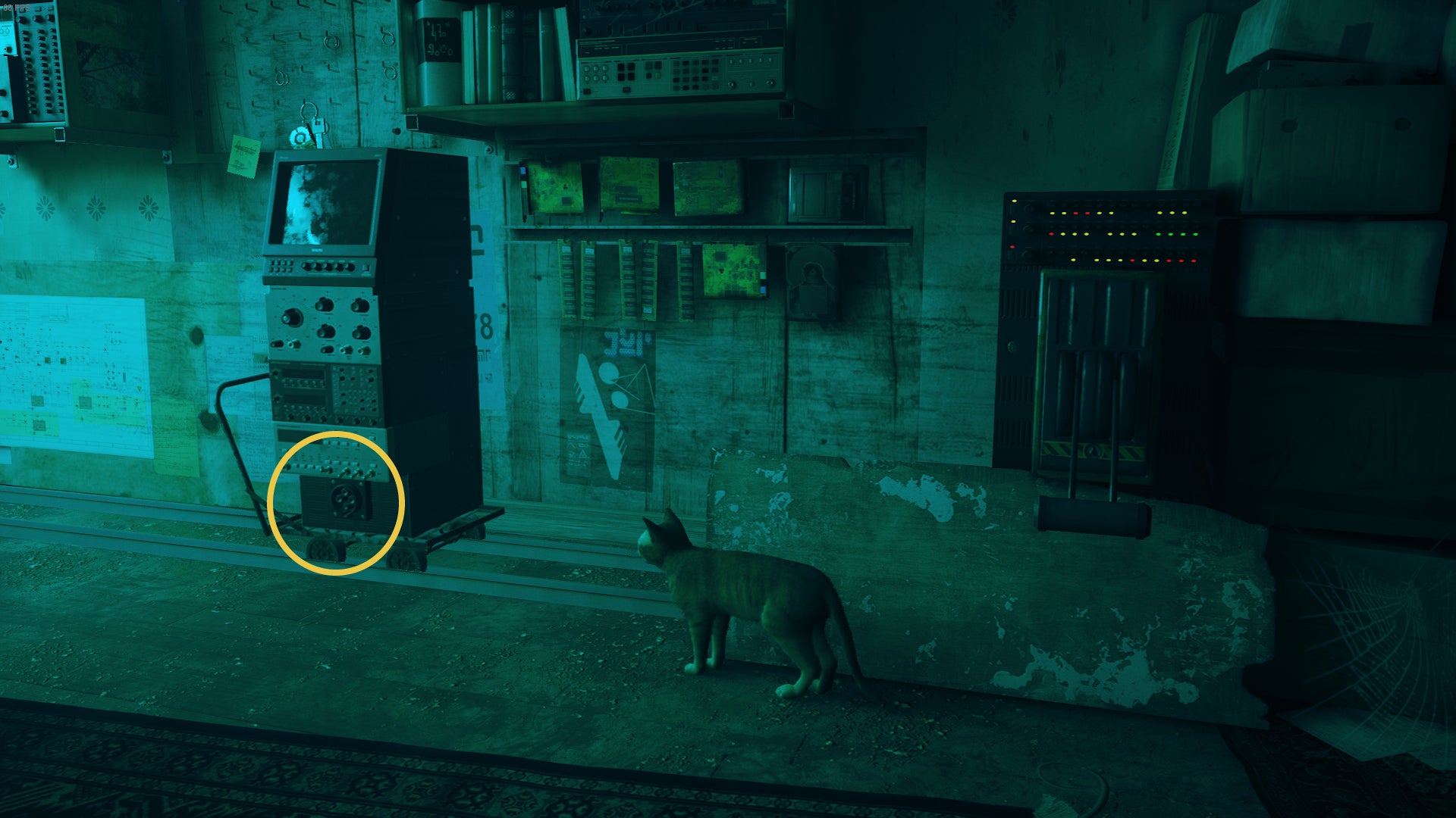 The Outsider, a cat, looks at a small computer on wheels with a plug in it in The Flats, Stray. - 6