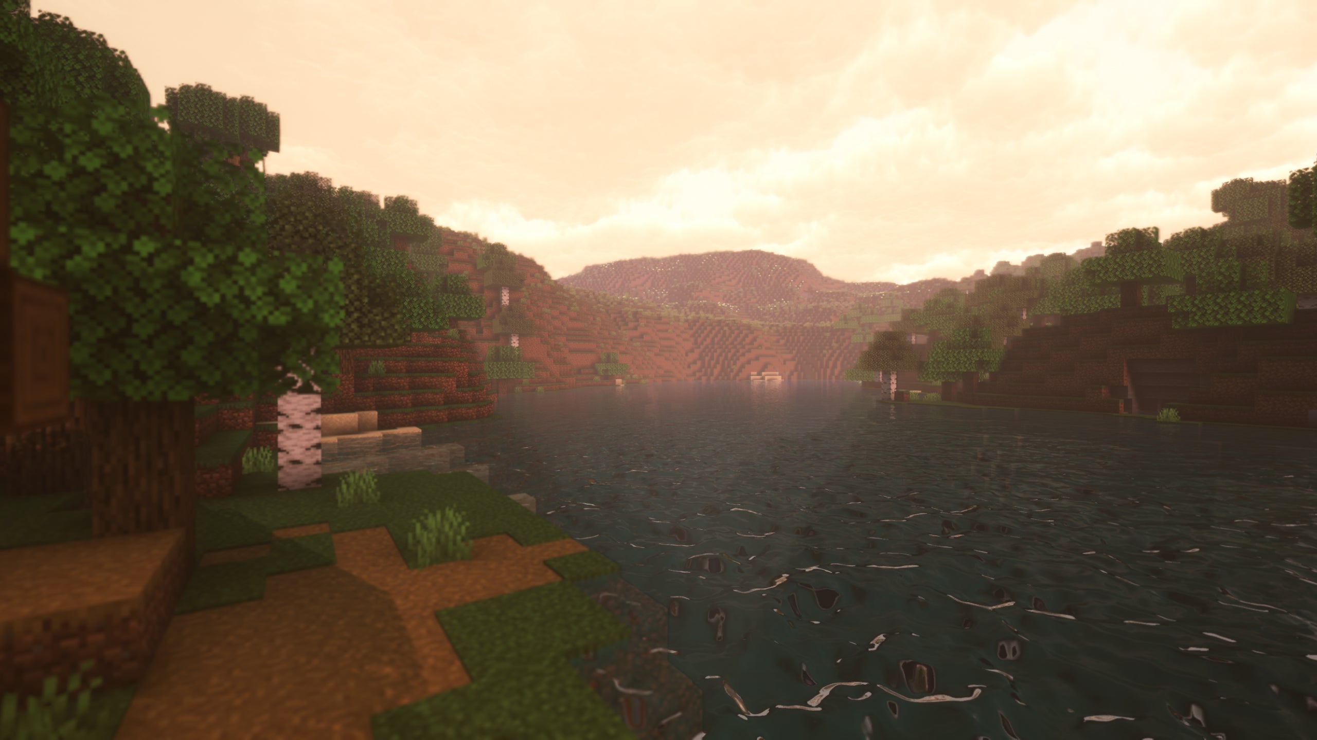 A screenshot of a river in Minecraft, with some trees on either side of the bank and a hill in the distance, taken using Sunflawer shaders.