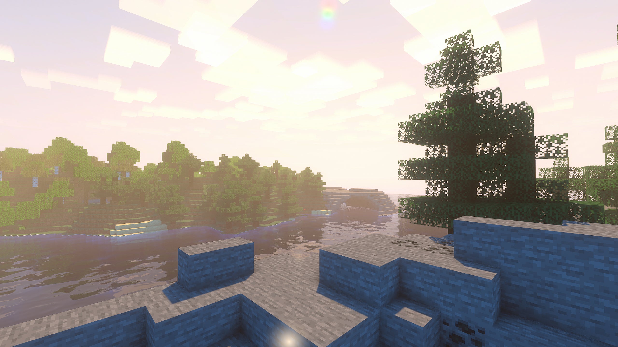 A rocky Minecraft landscape with a river in the background and Super Duper Vanilla Shaders installed.