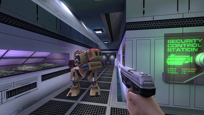 The player points a pistol at a robot in a space station corridor.