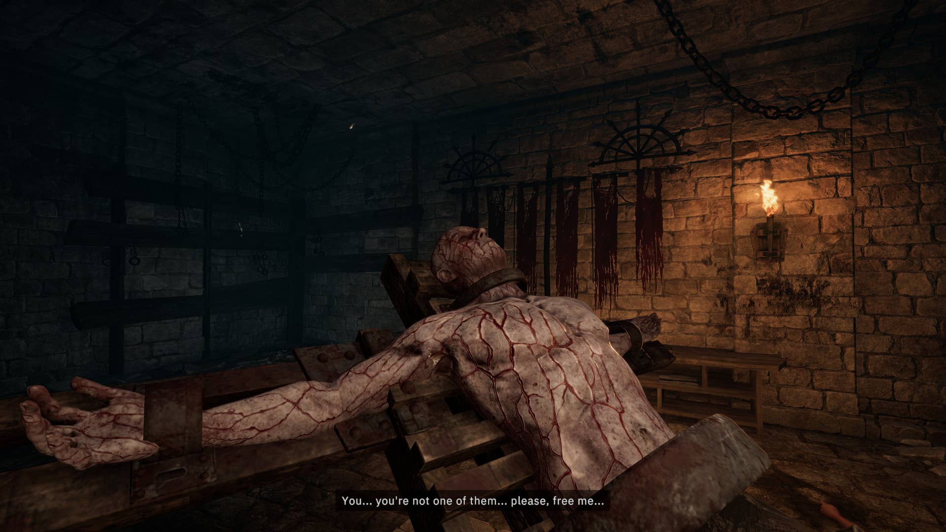 A man stretched out on a torture rack-like device and crisscrossed with bloody scars. He's in a dungeon of some kind and he believes we're here to help him, or give him mercy.