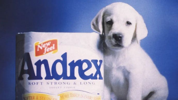 Anak anjing Andrex bersandar pada sebungkus tisu toilet.