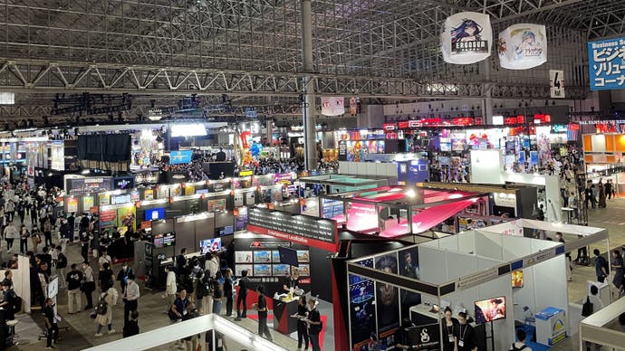 A view across the Tokyo Game Show showfloor, with various business stands and people milling around.
